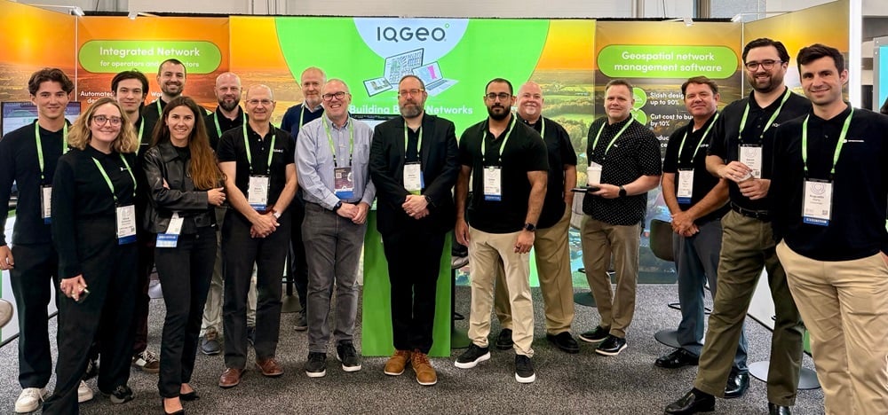 Fiber Connect 2025の会場で、IQGeoチームがブースの前に集まった