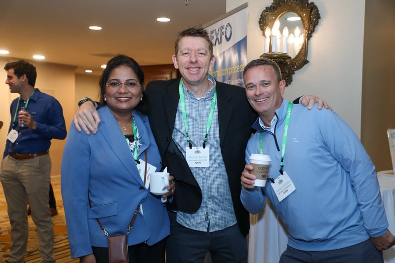2025年IQGeo Americas Meetup 参加した3人の代表者がカメラに向かって笑顔を見せる。
