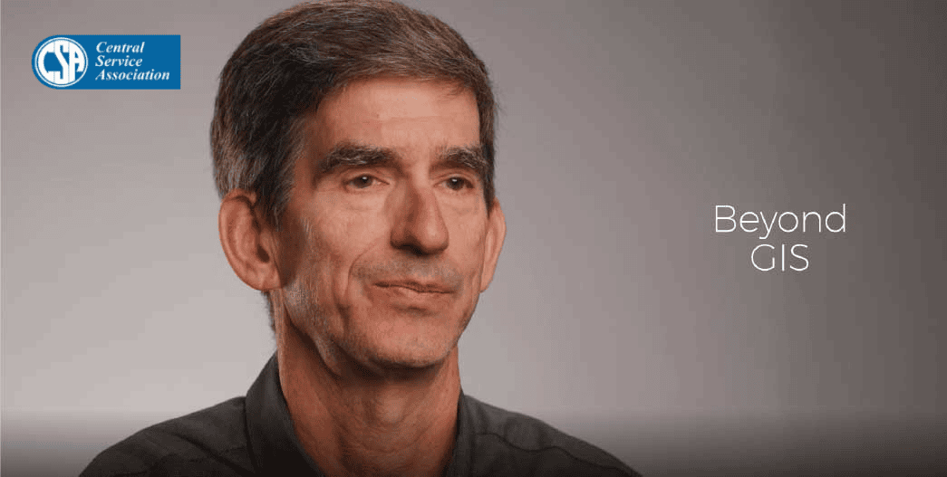 左上にCentral Service Association 、右側に「Beyond GIS」の文字が書かれたグレーの背景。画像中央には濃い色のシャツを着た人物が配置されている。